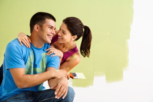 Smiling couple painting together.