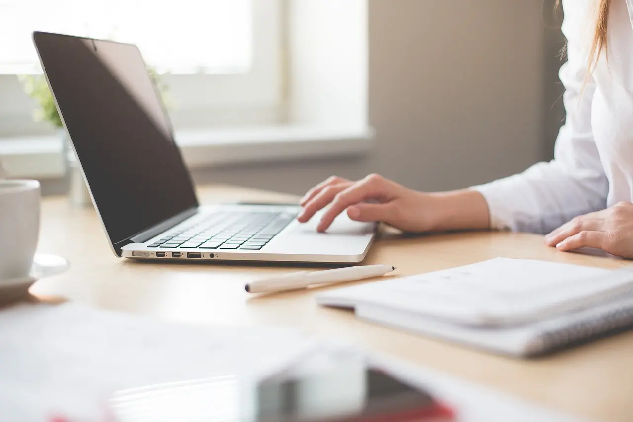 Laptop computer on table being used by a woman