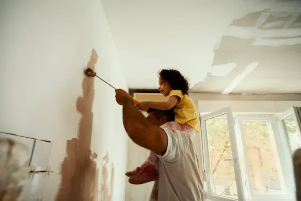 A man and child painting a wall