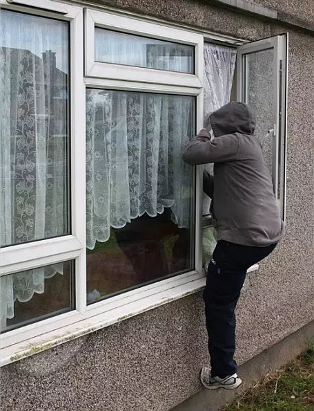 man climbing in window