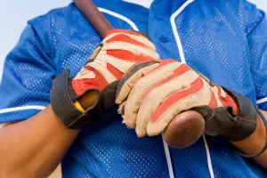 Gloved hands holding a baseball bat