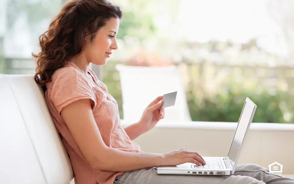 Woman with laptop and computer working on improving her credit score