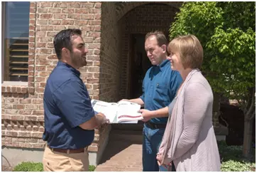 owners and a couple reviewing lease