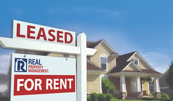 Two-story house with For Rent sign in foreground