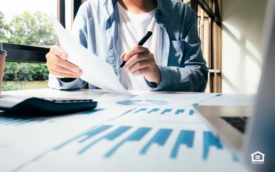 Charts on table with man holding paper