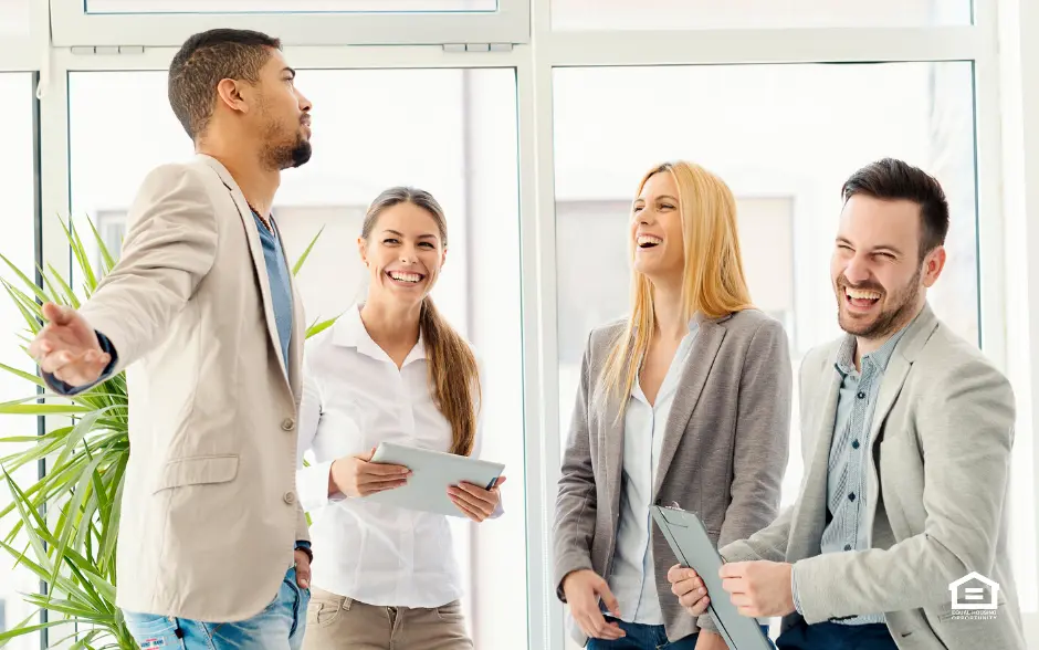 Four real estate professionals laughing and smiling