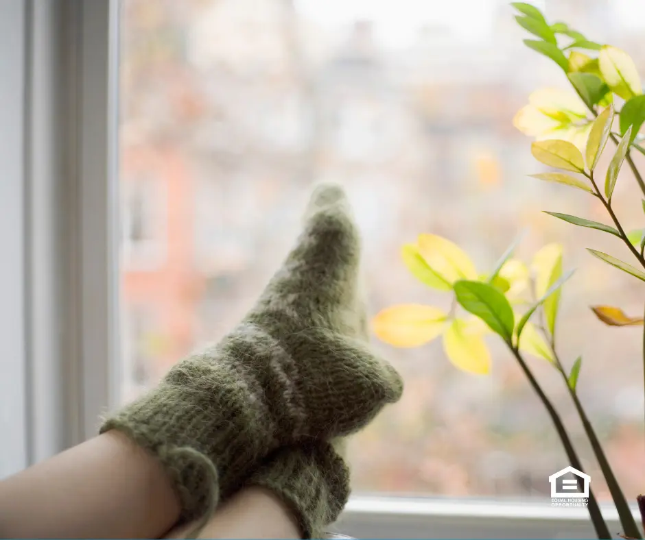 Feet with green socks resting on window sill