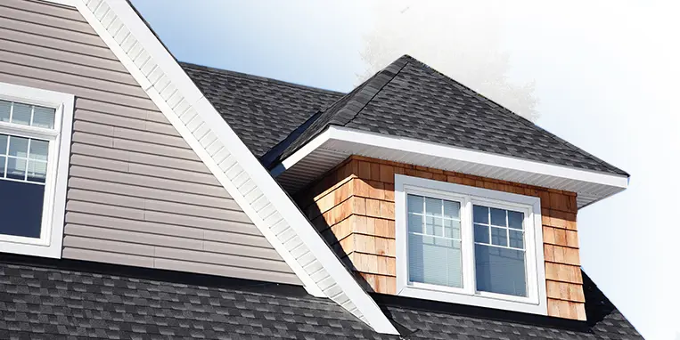 View of windows on second story of home with sky in background